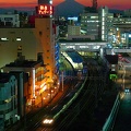 Un train quitte la <em>gare</em> de Fujisawa devant le <em>mont Fuji</em> au <em>crépuscule</em>