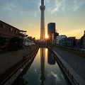 Derniers <em>rayons de soleil</em> derrière la Tokyo Skytree et son <em>reflet</em> dans l'eau tel un miroir