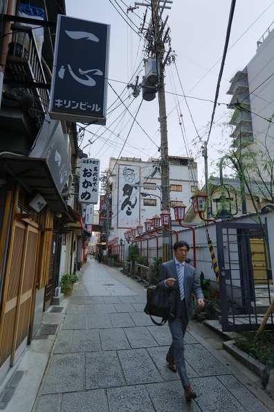 Salaryman marchant dans l'allée Hozenji Yokocho du quartier traditionnel Namba