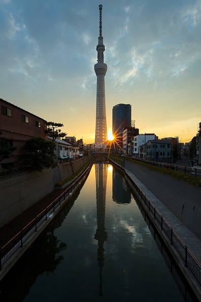 Derniers rayons de soleil derrière la Tokyo Skytree et son reflet dans l'eau tel un miroir